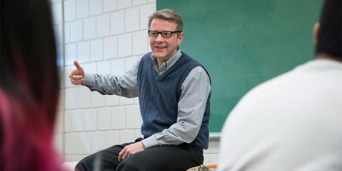 Faculty gesturing in front of class